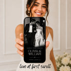 Bride holding a phone displaying an elegant black tie save the date website with couple photography and personalised wedding announcement.