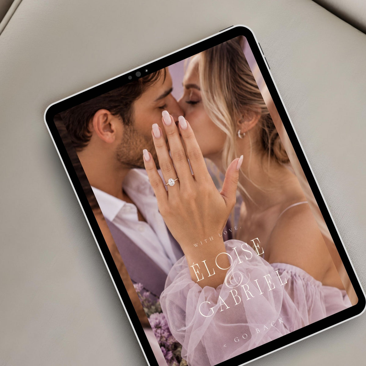 Romantic lavender wedding website displayed on a tablet featuring personalised couple photography and elegant wedding invitation styling.